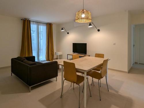 - un salon avec une table à manger et un canapé dans l'établissement Appartement Saint Ruf, à Avignon