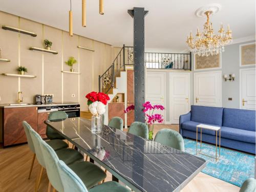 - une salle à manger avec une table, des chaises et un canapé bleu dans l'établissement Merveil - Luxury Suite - Louvre - Reaumur I, à Paris