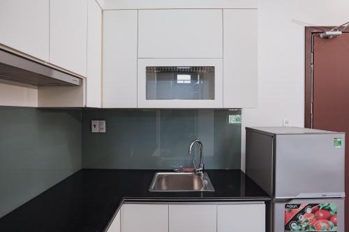 a kitchen with a sink and a refrigerator at The Eastern Hotel & Apartment in Hai Phong