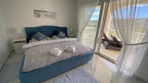 a bedroom with a blue bed and a balcony at Casa Blanca in Pag