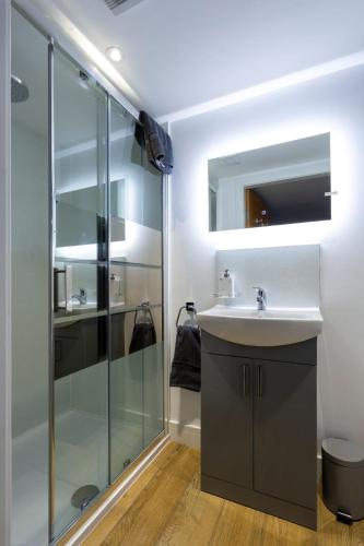 a bathroom with a sink and a shower at Merok Mill House & Old Granary in Six Road Ends