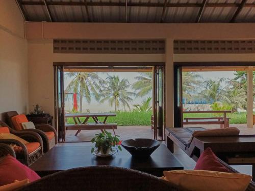 a living room with a table and chairs and a patio at Beach Front Villa, Saphli beach, Chumphon,Thailand in Ban Tha Samet (1)
