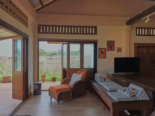 a living room with a couch and a tv at Beach Front Villa, Saphli beach, Chumphon,Thailand in Ban Tha Samet (1)