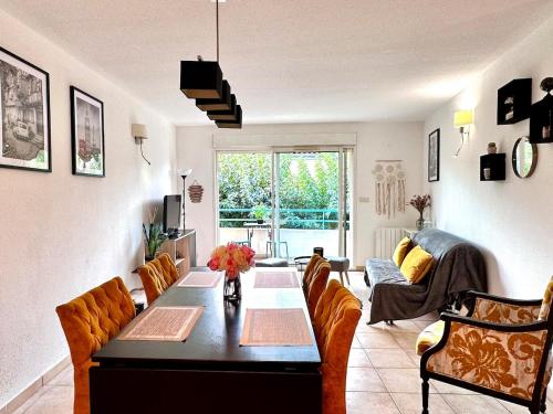 - un salon avec une grande table et des chaises dans l'établissement Le Paladio - Centre, Parking privé, CLIM, 4 personnes, à Istres