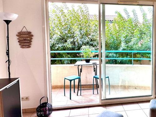 une pièce avec une table et des chaises sur un balcon dans l'établissement Le Paladio - Centre, Parking privé, CLIM, 4 personnes, à Istres