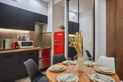 Il comprend une cuisine équipée d'une table avec des chaises et d'un réfrigérateur rouge. dans l'établissement Sublime flat in the centre of Paris by Studioprestige, à Paris