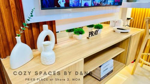 a wooden shelf with vases and a tv on it at MOA Newly Turn Over 1 bedroom with balcony PRIER Place in Manila