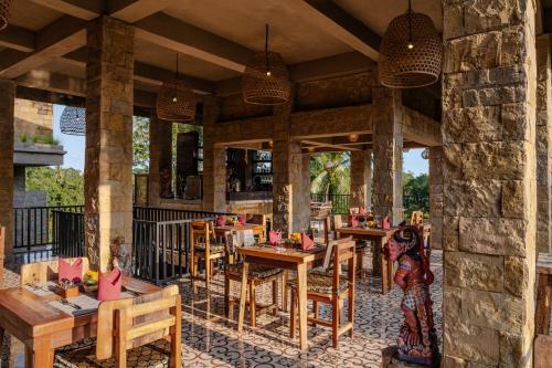 a restaurant with wooden tables and chairs on a patio at Hoshi Jungle Resort in Tegalalang