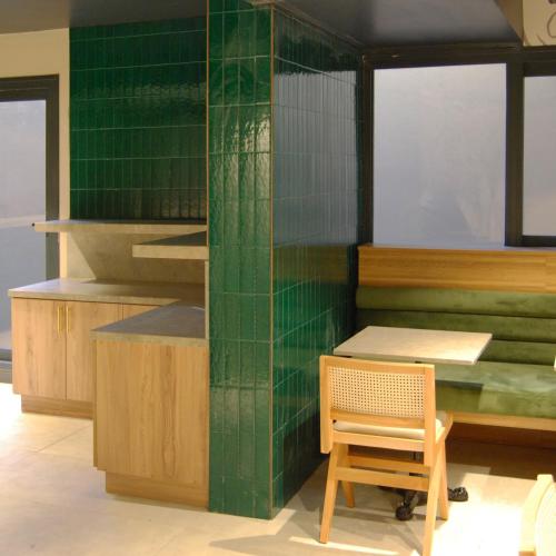 una cucina con pareti rivestite di piastrelle verdi, un tavolo e una sedia di CONCEPT PERA Hotel a Istanbul