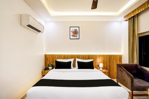 a hotel room with a bed and a chair at Townhouse GRAND ADDRESS HOTEL AND BANQUET in Ghaziabad