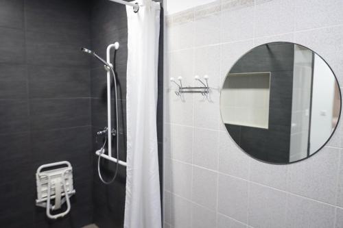 a bathroom with a shower with a mirror at Hôtel Le Lons in Foix
