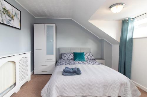 a bedroom with a white bed with a blue pillow at Thornbury Guest House Room 8 in Southampton