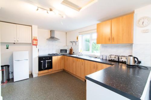 a kitchen with wooden cabinets and a black counter top at Thornbury Guest House Room 8 in Southampton