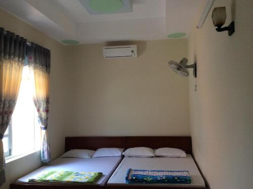 a small bedroom with a bed with a window at Quốc Ân Motel in Long Hai