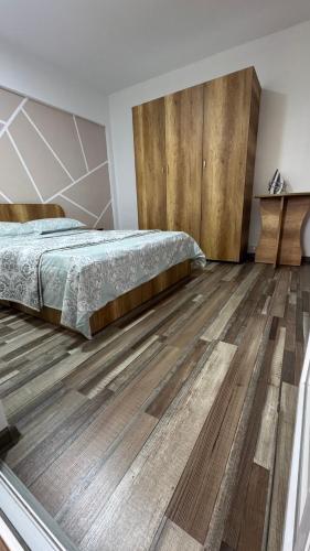 a bedroom with a bed and a wooden floor at CoraHome Ultra Central in Corabia