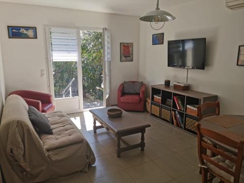 Una sala de estar con un sofá y un televisor. en U Casetta, en Patrimonio