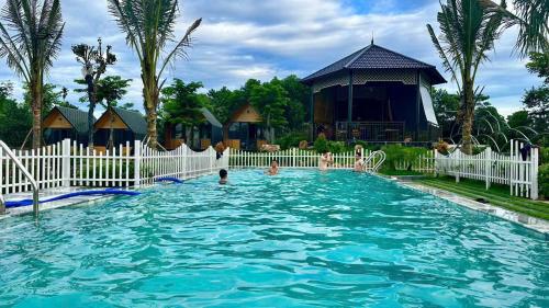 Trai SonにあるYellow Homestayの白い柵とそこにいる人々のあるプール