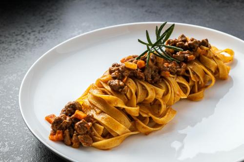 a plate of food with pasta on a table at Boutique Hotel Planlim in Ortisei