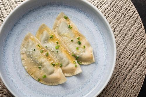 two dumplings on a white plate on a table at Boutique Hotel Planlim in Ortisei