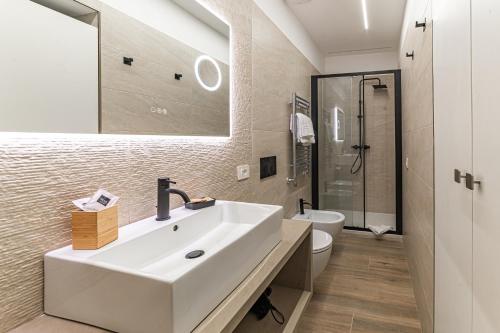 Un baño blanco con lavabo e inodoro. en Vatican Suites Apartment - Vatican City, en Roma