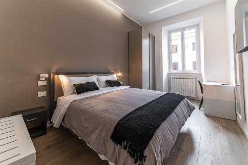 Un dormitorio con una cama grande y una ventana. en Vatican Suites Apartment - Vatican City, en Roma