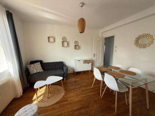 un salon avec une table, des chaises et un canapé dans l'établissement Comfort in the Heart of Dijon, à Dijon