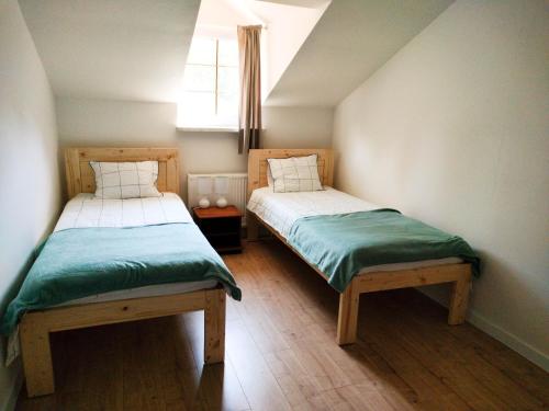 two beds in a small room with a window at Uroczysko Jakubowo in Dąbrówno