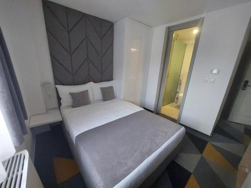 a bedroom with a large white bed in a room at Hotel Boutique Bristol in Sarajevo