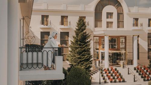 a woman standing on a balcony of a building at Epirus Palace Congress & Spa in Ioannina