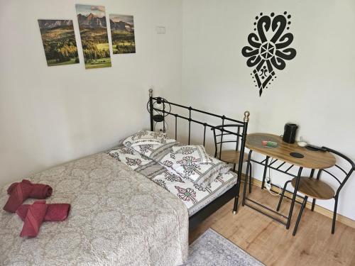 a bedroom with a bed and a table and a chair at Pokoje gościnne Zosia in Kościelisko