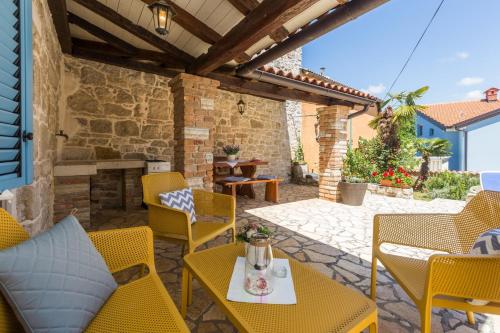 een patio met stoelen en tafels en een open haard bij St. Bernhard House in Funtana