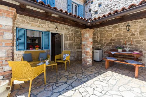 een patio met stoelen, een tafel en een bank bij St. Bernhard House in Funtana