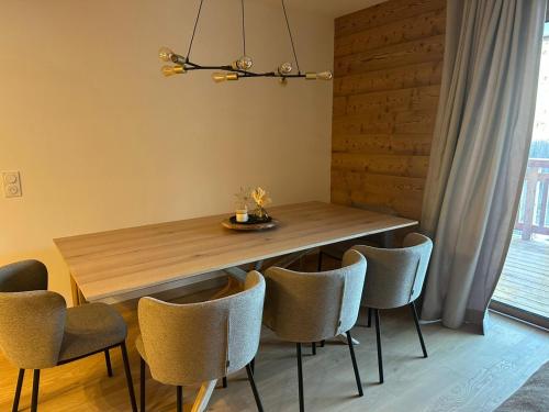 a dining room with a wooden table and chairs at Snow Roc Mountain View in Saint-Jean-dʼAulps