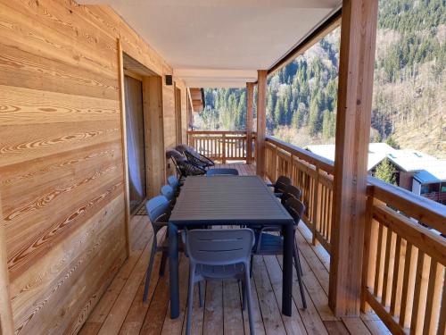a table and chairs on a deck with a view at Snow Roc Mountain View in Saint-Jean-dʼAulps