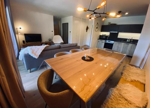 a living room with a wooden table and a couch at Snow Roc Mountain View in Saint-Jean-dʼAulps