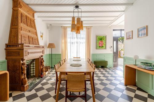 une salle à manger avec une table et une cheminée dans l'établissement Maison Bois Roux Charme & confort à 200m de la mer, à Préfailles