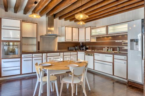 - une cuisine avec une table en bois et des chaises blanches dans l'établissement Geoffroy sublime duplex à proximité de la place du vieux marché, à Rouen
