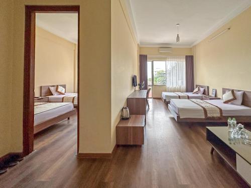 a hotel room with two beds and a mirror at BIDV Hotel Đồ Sơn in Ðố Sơn