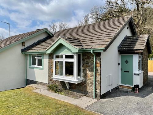 a small brick house with a green door at Your Saundersfoot getaway - relax explore and make memories at Berts Bungalow in Saundersfoot