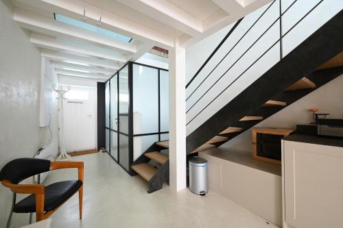un salon avec un escalier et une chaise dans l'établissement 535 Le Duplex - Renovated and bright house, à Saint-Martin-de-Ré