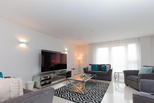 a living room with couches and a flat screen tv at Luxurious Central Edinburgh Apartment - Sleeps 6 in Edinburgh