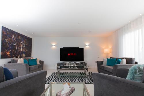 a living room with couches and a flat screen tv at Luxurious Central Edinburgh Apartment - Sleeps 6 in Edinburgh