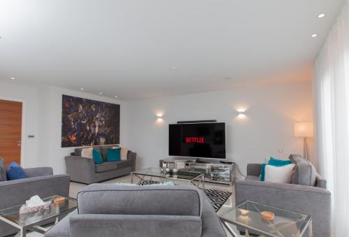 a living room with couches and a flat screen tv at Luxurious Central Edinburgh Apartment - Sleeps 6 in Edinburgh