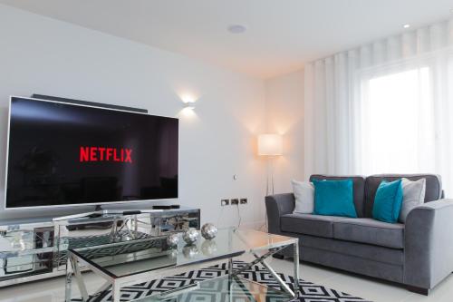 a living room with a tv and a couch at Luxurious Central Edinburgh Apartment - Sleeps 6 in Edinburgh