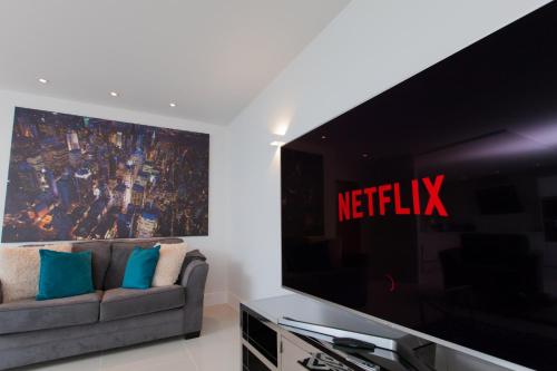 a living room with a tv and a couch at Luxurious Central Edinburgh Apartment - Sleeps 6 in Edinburgh