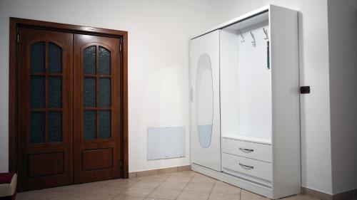 a bathroom with a sink and a wooden door at Paris's Apartment in Gjirokastër