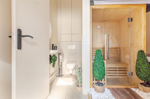 une salle de bain avec une douche avec des arbres en pot dedans dans l'établissement Duplex Luxe - Sauna & Jacuzzi Privatif, à Montrouge