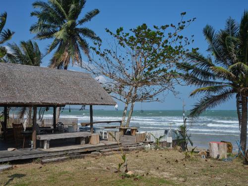 a beach with a pavilion and palm trees and the ocean at Beach Front Villa, Saphli beach, Chumphon,Thailand in Ban Tha Samet (1)