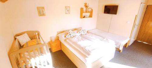 a small bedroom with two beds and a crib at Pension Bílý Hořec in Vrchlabí