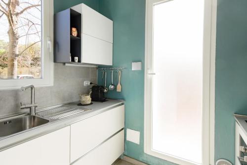 a kitchen with a sink and a window at La Posta Di Cadimare - Chill in the Mezzanine Bedroom at a Former Post Office in Fezzano